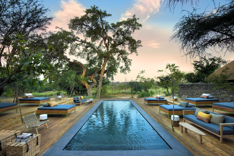 10-best-lodges-in-the-sabi-sand-game-reserve-3.jpg The image showcases the luxurious Lion Sands River Lodge, nestled in the Sabi Sand Game Reserve, with stunning views of the Sand River. The lodge features private plunge pools and spacious suites, offering an authentic safari experience amidst the abundant wildlife of South Africa's Kruger National Park.