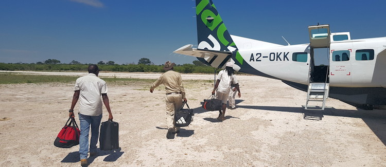 Light aircraft Botswana aerial fire contrast black brown green blue Okavango Delta otherworldly landscape