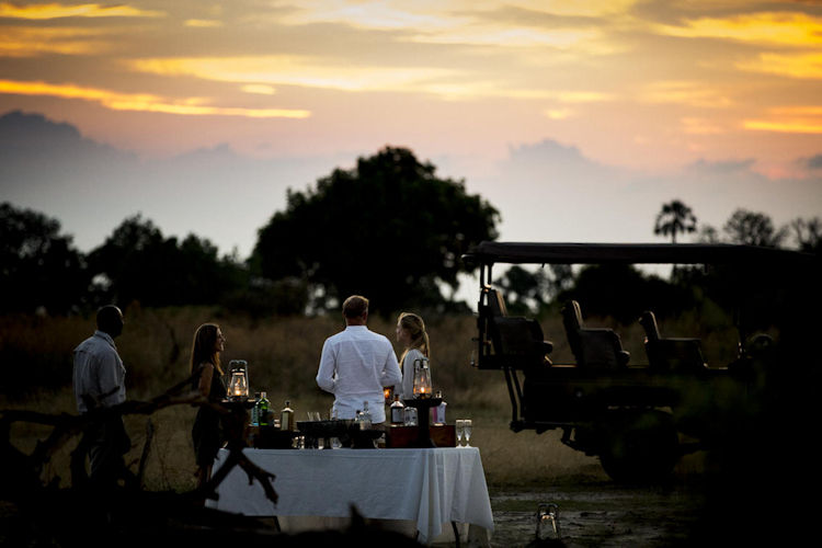 Romantic dinner sundowners Okavango Delta private deck champagne fire stars honeymoon Botswana