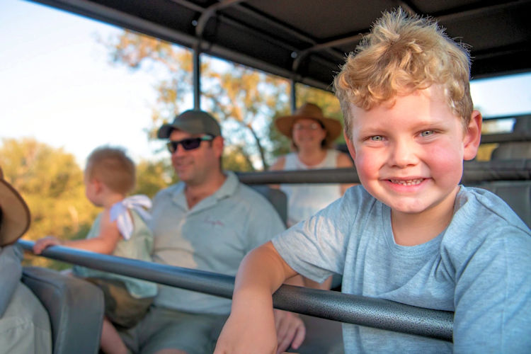 A family experiencing wildlife safaris in open-top vehicles.