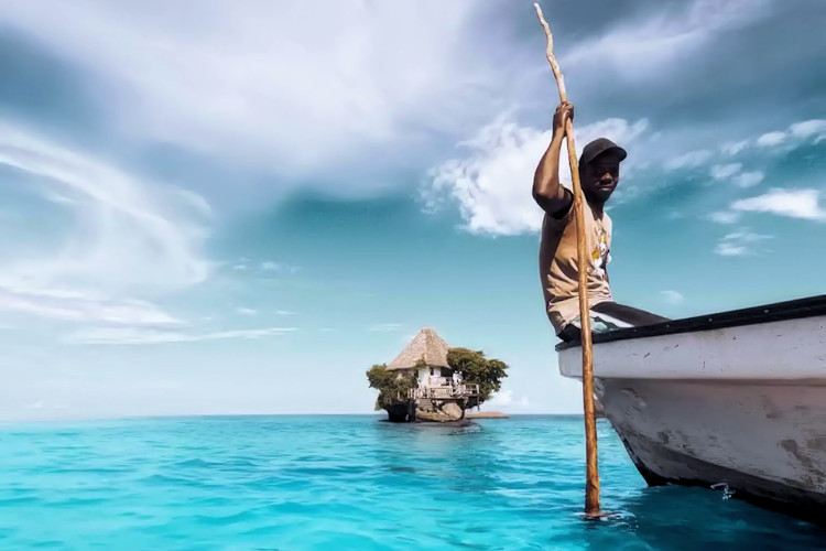 The Rock Restaurant Zanzibar Indian Ocean perched rock fresh lobster seafood wooden boat high tide