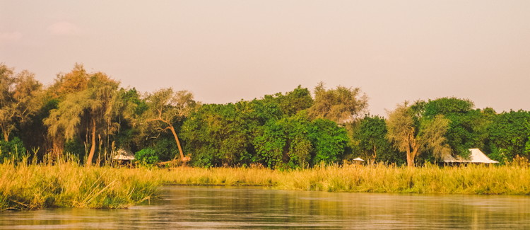 Sausage Tree Camp Lower Zambezi lunch barbecue table chairs ankle-deep Zambezi River cocktails crew waiting
