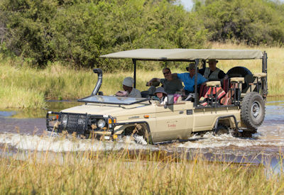 Game drive vehicle water crossing Khwai Concession Botswana Blooming Desert Safari mobile