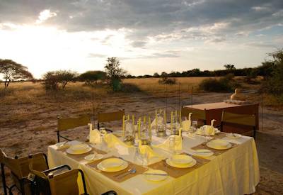 Outdoor dining open fire Discover Botswana luxury mobile tented safari Moremi Savuti