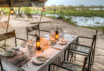 Open fire dining Shinde Footsteps Camp Okavango Delta eco family safari Botswana