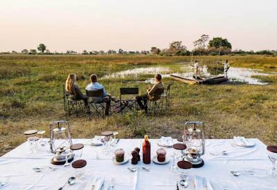 Outdoor dining fire under stars Okavango Delta mobile expedition Botswana