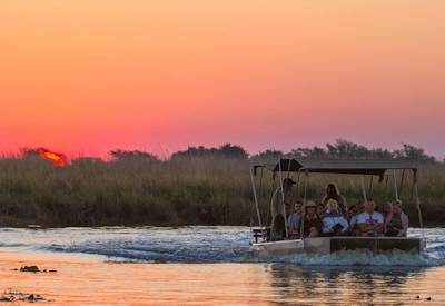 Boat cruises and sunset over the Chobe