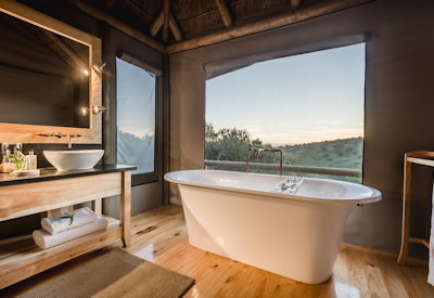 En-suite bathroom with spa bath overlooking African bush at Amakhala Bukela Lodge Eastern Cape