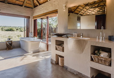 En-suite bathroom with spa bathtub and indoor outdoor showers at Amakhala Hlosi Lodge Eastern Cape