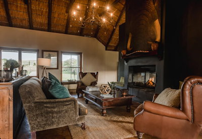 Elegant lounge and dining area with fireplace at Amakhala Hlosi Lodge Amakhala Game Reserve