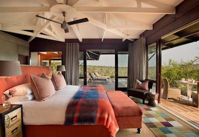 Luxury safari suite with glass doors and vibrant decor at Kwandwe Ecca Lodge Kwandwe Reserve