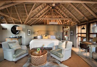 Spacious suite with floor-to-ceiling glass doors at Kwandwe Great Fish River Lodge Eastern Cape