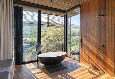 En-suite bathroom with indoor bath and outdoor shower at Shamwari Bayethe Tented Lodge Shamwari