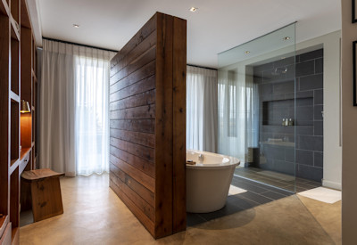 Modern en-suite bathroom with bathtub and walk-in shower at Shamwari Sarili Lodge Eastern Cape