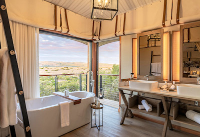 En-suite bathroom with bathtub and indoor outdoor shower at Shamwari Sindile Eastern Cape