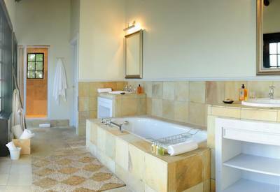 Elegant en-suite bathroom with indoor and outdoor shower at Shamwari Lobengula Lodge Shamwari