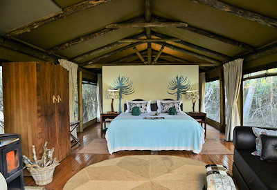 Elegantly furnished tented suite with king-size bed at Sibuya River Camp Sibuya Game Reserve