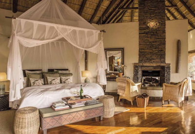 Luxurious thatched bedroom with king-size bed at Tuningi Safari Lodge Madikwe