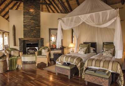 Beautifully appointed suite with fireplace and sitting area at Tuningi Safari Lodge Madikwe