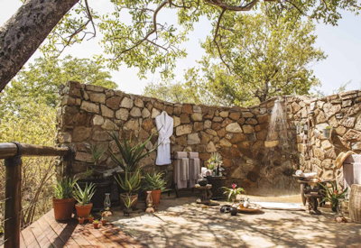 Outdoor shower in en-suite bathroom at Tuningi Safari Lodge Madikwe Game Reserve