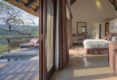 Thatched luxury suite with king-size bed and private plunge pool at AndBeyond Phinda Mountain Lodge