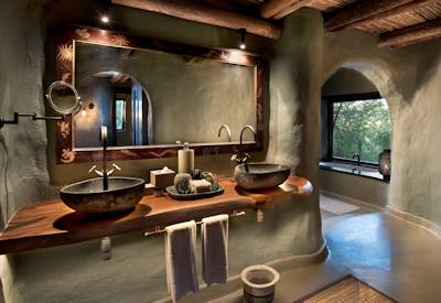 Luxury en-suite bathroom with outdoor shower at AndBeyond Phinda Rock Lodge Phinda Reserve