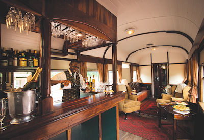 Rovos Rail bar car barman champagne mahogany Southern Cross luxury train safari South Africa