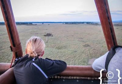 Masai Mara balloon safari Kenya dawn red tinge savannah near silence black rhino Topi shadow below