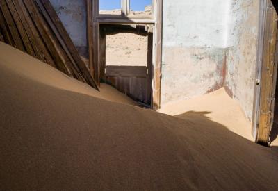 Kolmanskop ghost town buildings amid Namib Desert sand dunes Luderitz Namibia aerial