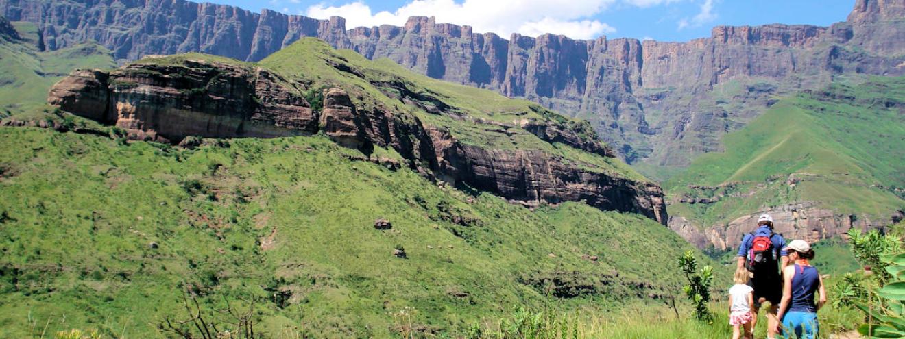 Family hiking in the Drakensberg mountains — stunning mountain scenery near the best Drakensberg accommodation and boutique lodges in KwaZulu-Natal