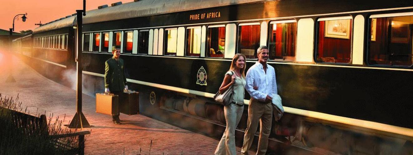 A couple boarding the Rovos Rail Pride of Africa luxury train at sunset on a South Africa train safari