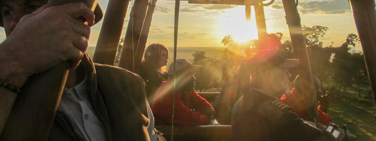 Explore Masai Mara by balloon Kenya Governors Company near silence dawn breaking red tinge savannah