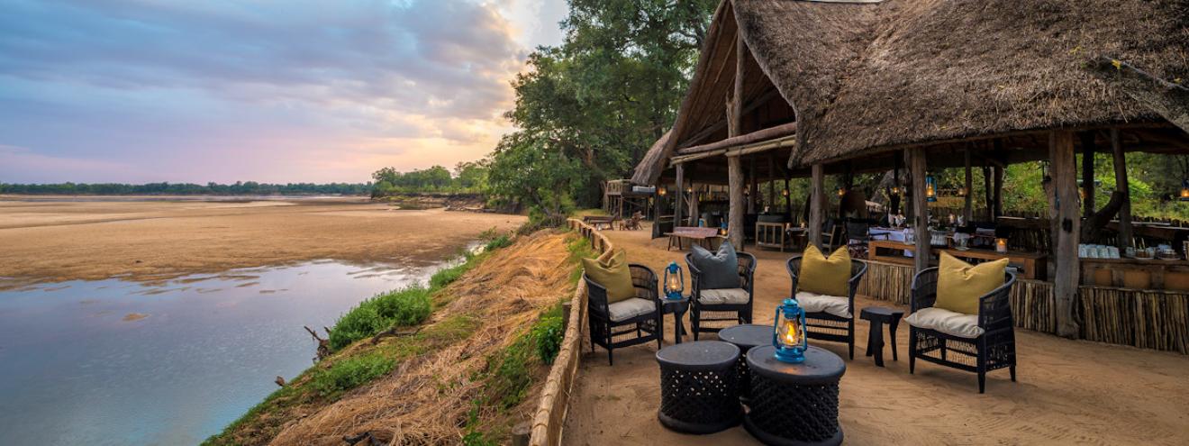 Chamilandu Bushcamp exclusive thatched stilt chalets elevated high on wooden platforms along the Luangwa River