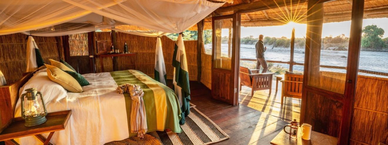 Nsolo Camp classic thatched chalets set on raised wooden decks overlooking the dry Luwi River bed