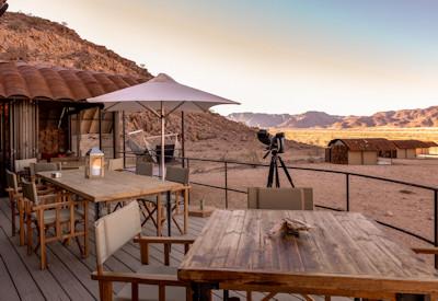 A traditional lodge with outdoor dining area and central lounge