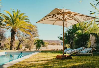 A swimming pool with sun loungers and a view with local wildlife