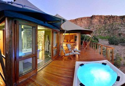 Tented suites set in a horseshoe bend of a dry karoo ravine