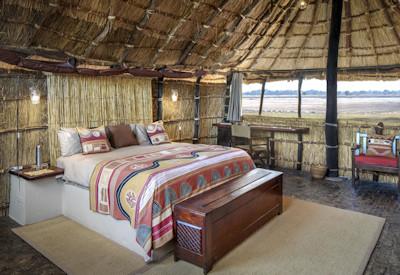 Thatched safari suites overlooking the camp waterhole