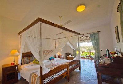 Bluebay Beach Resort large en-suite bedroom four-poster bed mosquito net Zanzibar