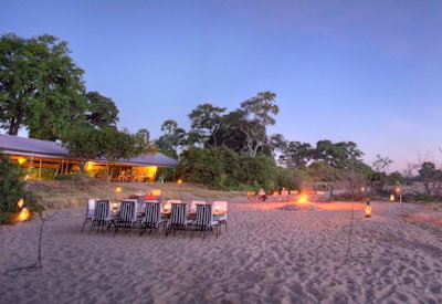 Kwihala Camp outdoor dining dry riverbed under African stars Ruaha National Park Tanzania