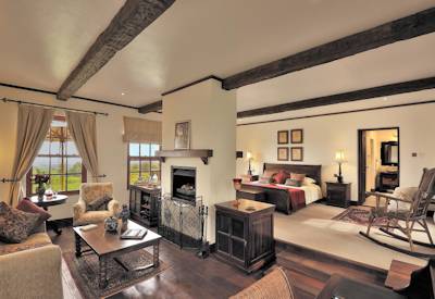The Manor at Ngorongoro farmhouse lounge fireplace grand piano high stools bar Tanzania