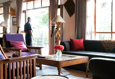 Ngorongoro Farm House main lounge brick fireplace whitewashed walls thatched roof Tanzania