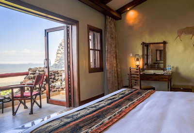 Ngorongoro Serena Safari Lodge bedroom embossed leather headboard brass lamps Tanzania