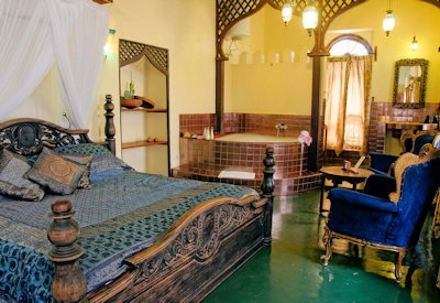 Zanzibar Palace Hotel bedroom wood brass bed colourful silk Arabian Indian design Zanzibar