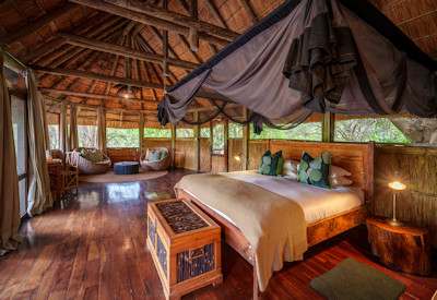 Cozy main boma lounge deck overlooking a permanent waterhole at Bilimungwe Bushcamp