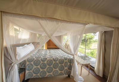 Large luxury en-suite bathroom featuring double vanities and an outdoor shower at Chikunto Safari Lodge
