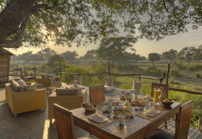 Relaxed open-sided bar area with sofas at Flatdogs Camp in South Luangwa National Park, Zambia