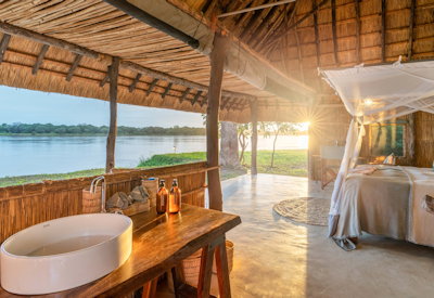Spacious and airy canvas safari tent interior featuring a comfortable bed and private viewing deck at Kakuli Bush Camp