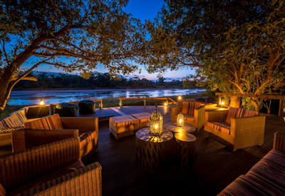 The central main boma guest area featuring a thatched dining room and lounge at Kapamba Bushcamp