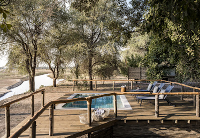 Beautifully designed en-suite bathroom featuring an open-air shower under the trees at Kulandila Camp